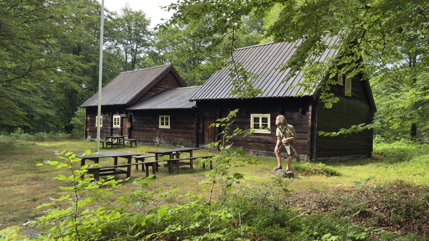 Dunkles, teergeschwärztes Blockhaus auf einer Waldlichtung bei Osby
